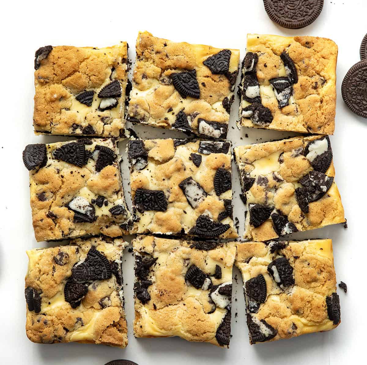 Oreo Chocolate Chip Cheesecake Bars cut into squares on a white table from overhead.