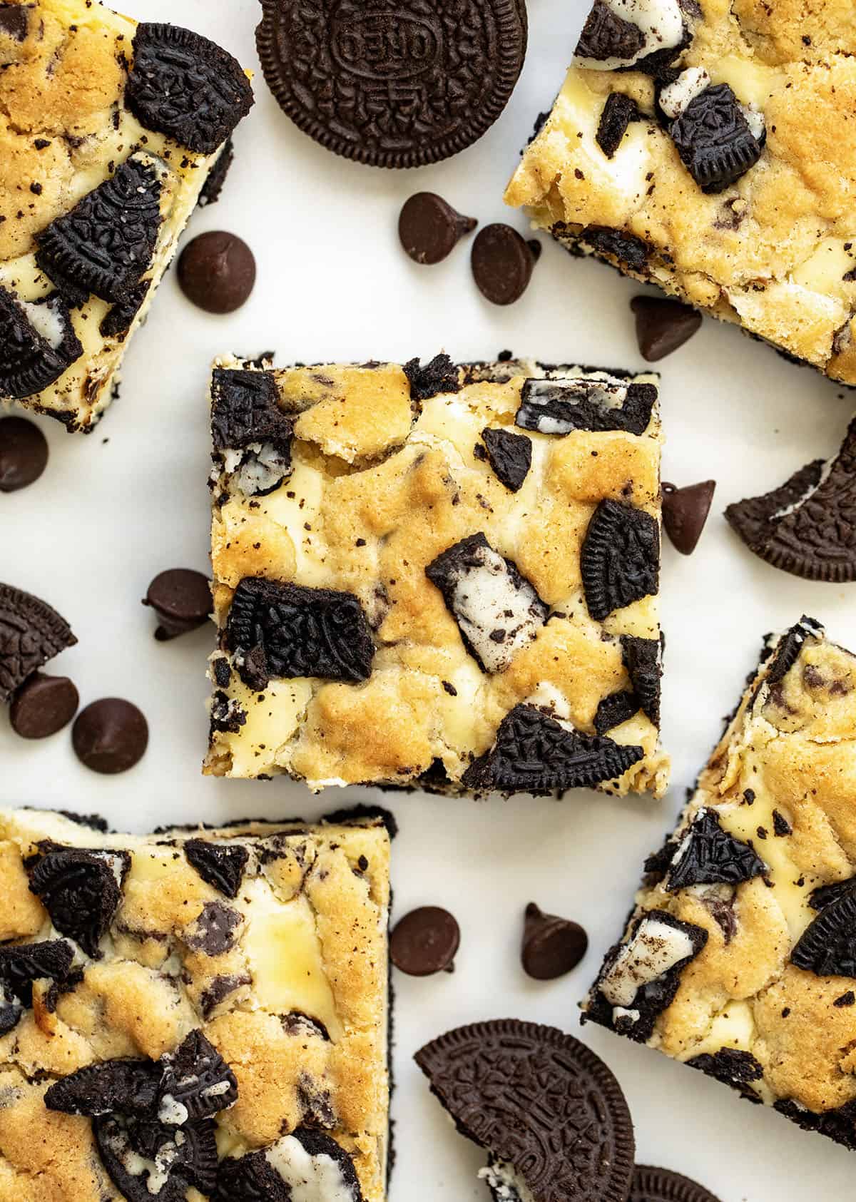 Close up of Oreo Chocolate Chip Cheesecake Bars on a white table from overhead.