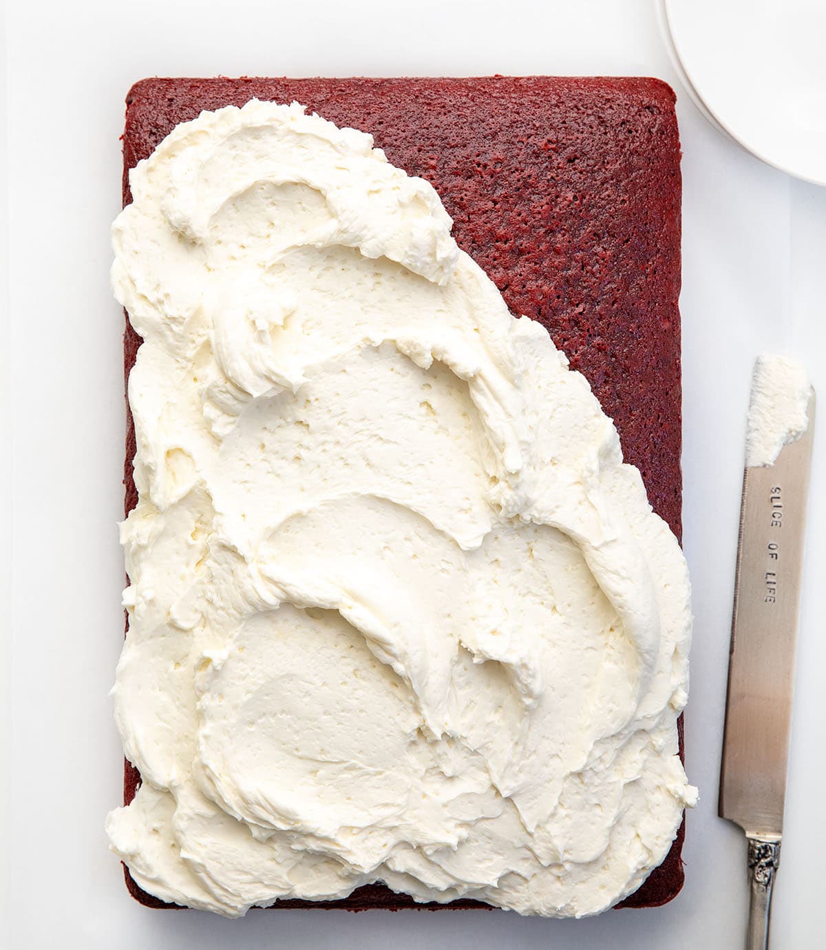 This Easy Red Velvet Sheet Cake delivers all the classic red velvet flavor! Topped with light, silky Ermine frosting, itโs perfect for birthdays, holidays, or just a sweet treat to share! Red Velvet Sheet Cake with the ermine frosting not quite covering the whole cake.