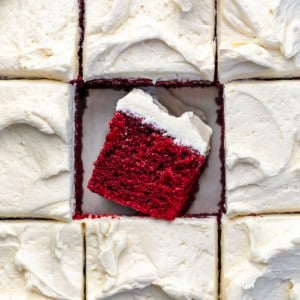 Red Velvet Sheet Cake cut into pieces with the center piece on its side showing the tender texture.
