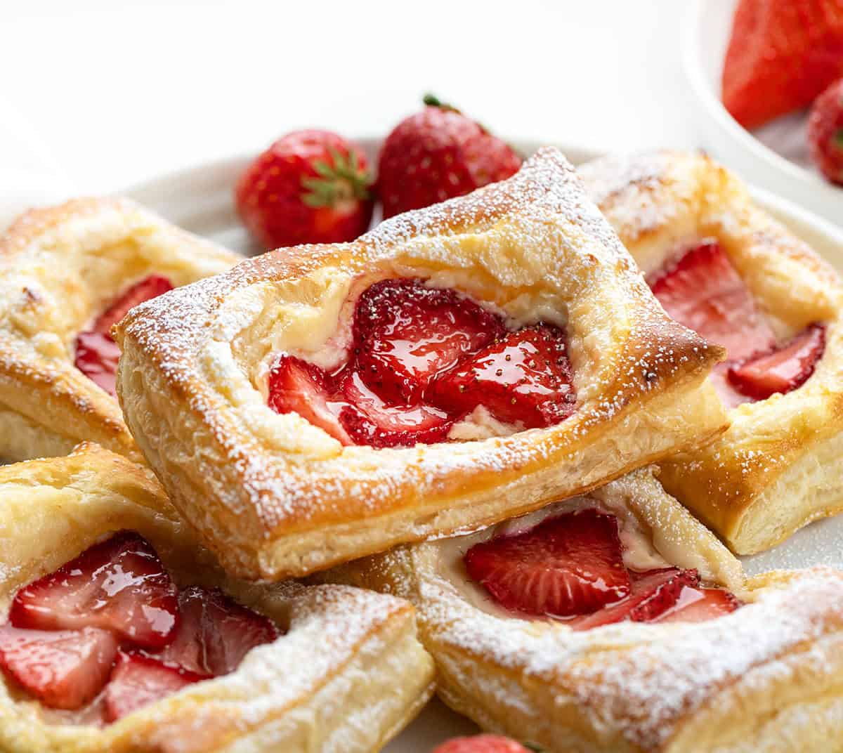 Close up of Strawberry Cream Cheese Danish on a white plate on a white table.