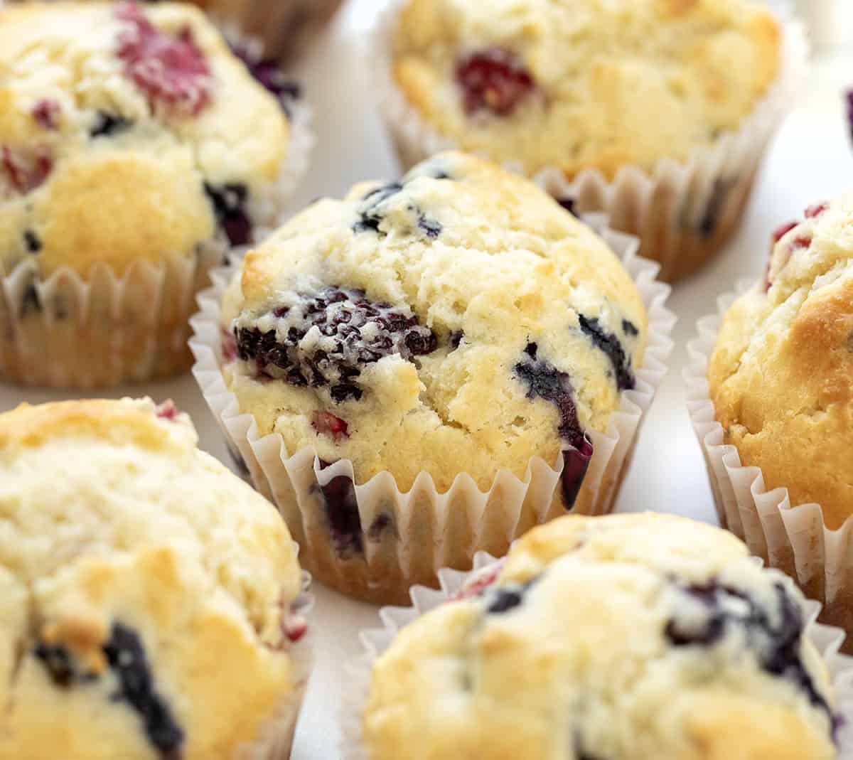Soft, tender, and filled with a triple threat of flavor, these Triple Berry Muffins are packed with juicy blueberries, raspberries, and blackberries in every bite! Triple Berry Muffins very close up.