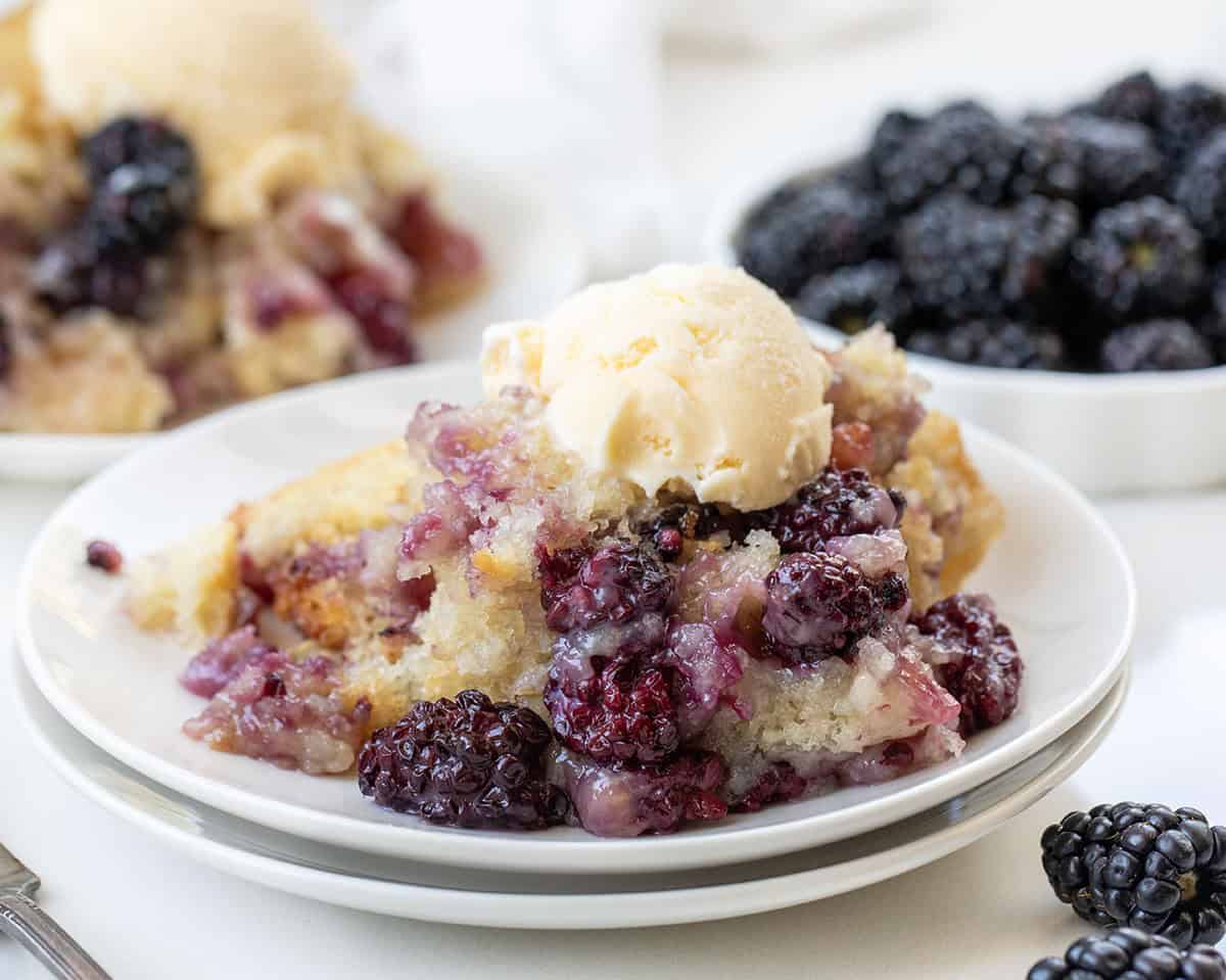 Close up of a plate of Blackberry Cobbler with ice cream on it.