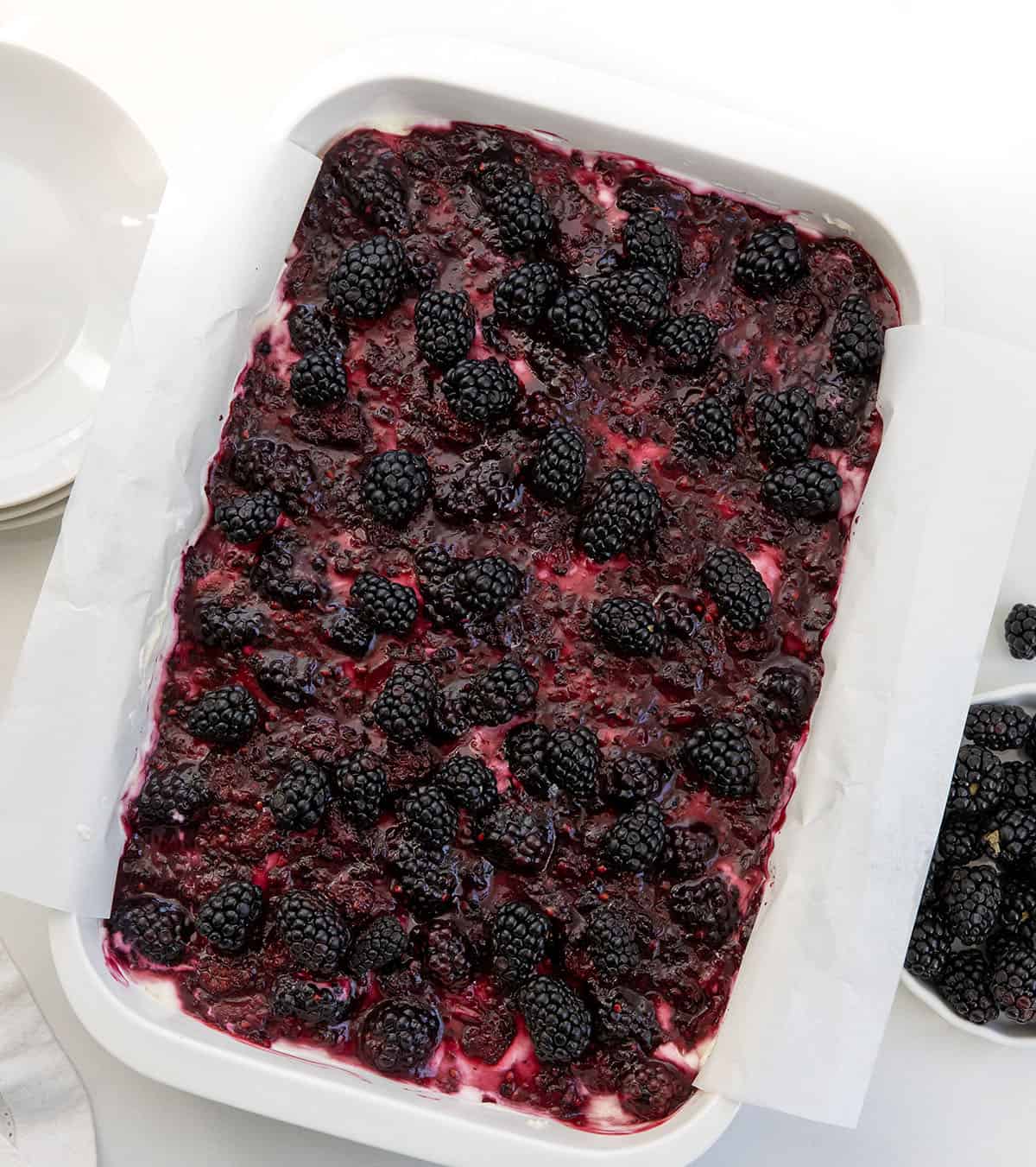 White pan of Blackberry Cream Cheese Bars on a white table from overhead.