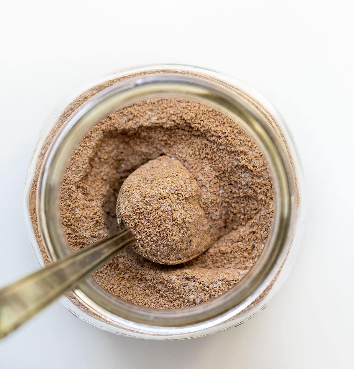 Jae of Chocolate Pudding Mix with a spoon in it from overhead.
