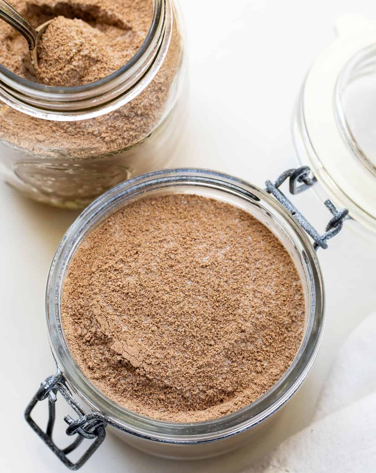 Containers of Chocolate Pudding Mix on a white table.