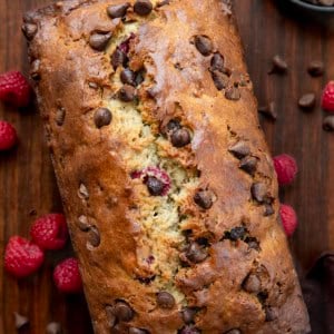 Loaf of Chocolate Raspberry Banana Bread on a wooden table from overhead.
