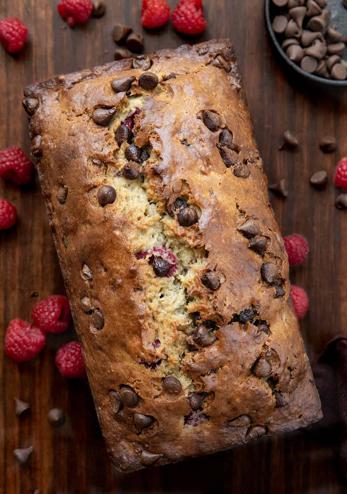 Loaf of Chocolate Raspberry Banana Bread on a wooden table from overhead.