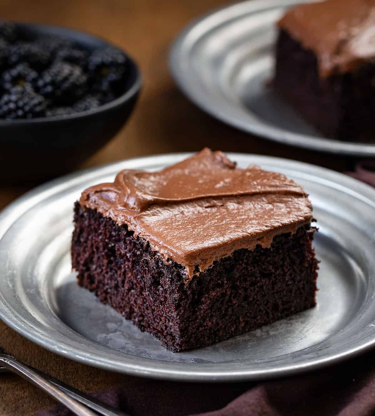 PIece of Devil's Food Sheet Cake on a metal plate on a wooden table.