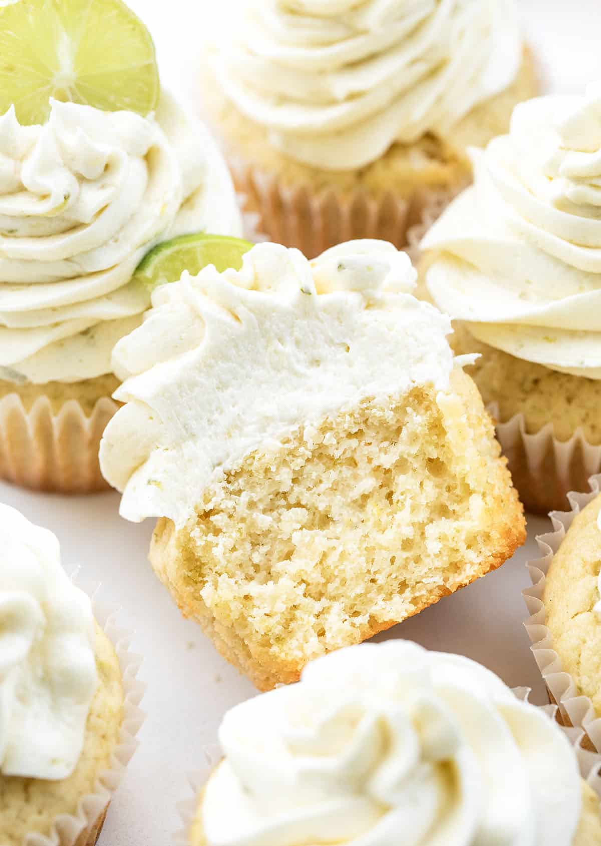 One halved Key Lime Cupcake in the middle of more Key Lime Cupcakes.