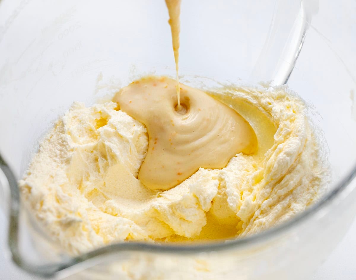 Adding the orange flour mixture to butter and sugar to make Orange Ermine Frosting.