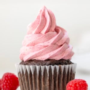 Raspberry Ermine Frosting piped onto a chocolate cupcake close up.