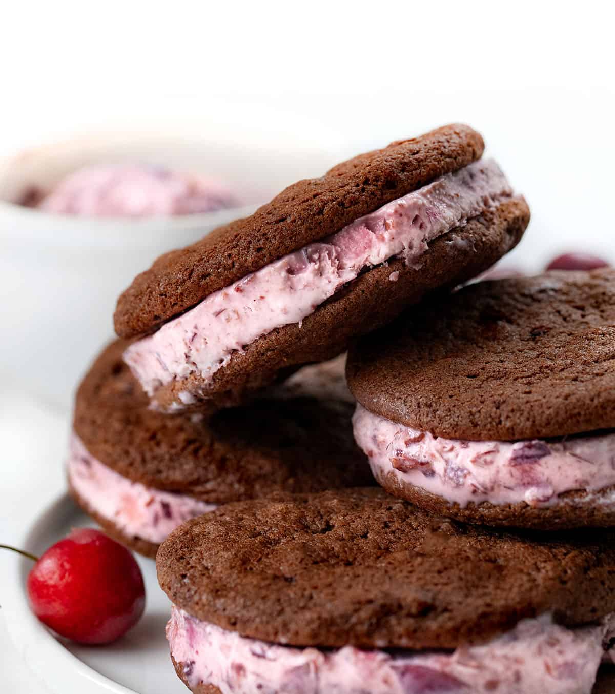 Chocolate Cherry Ice Cream Sandwiches stacked on a white plate.