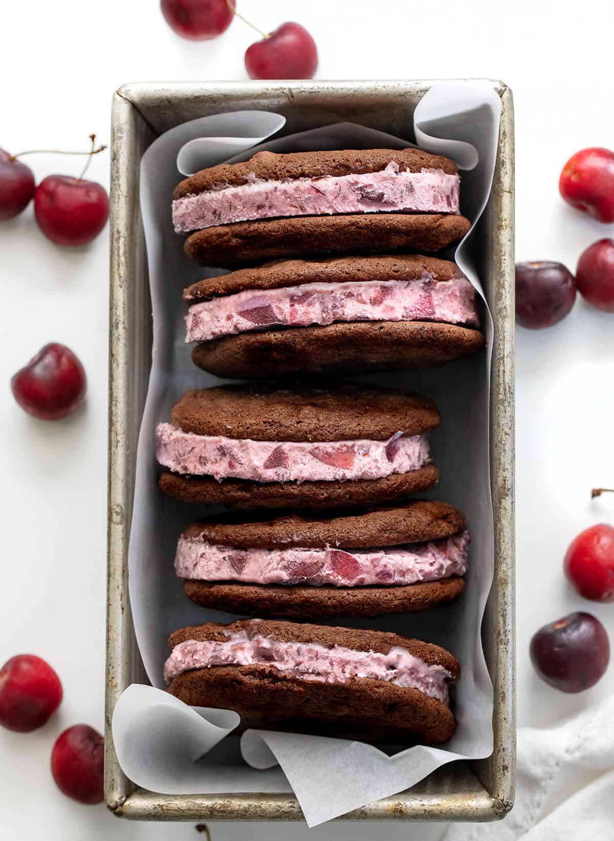 Chocolate Cherry Ice Cream Sandwiches in a pan on a white table. 