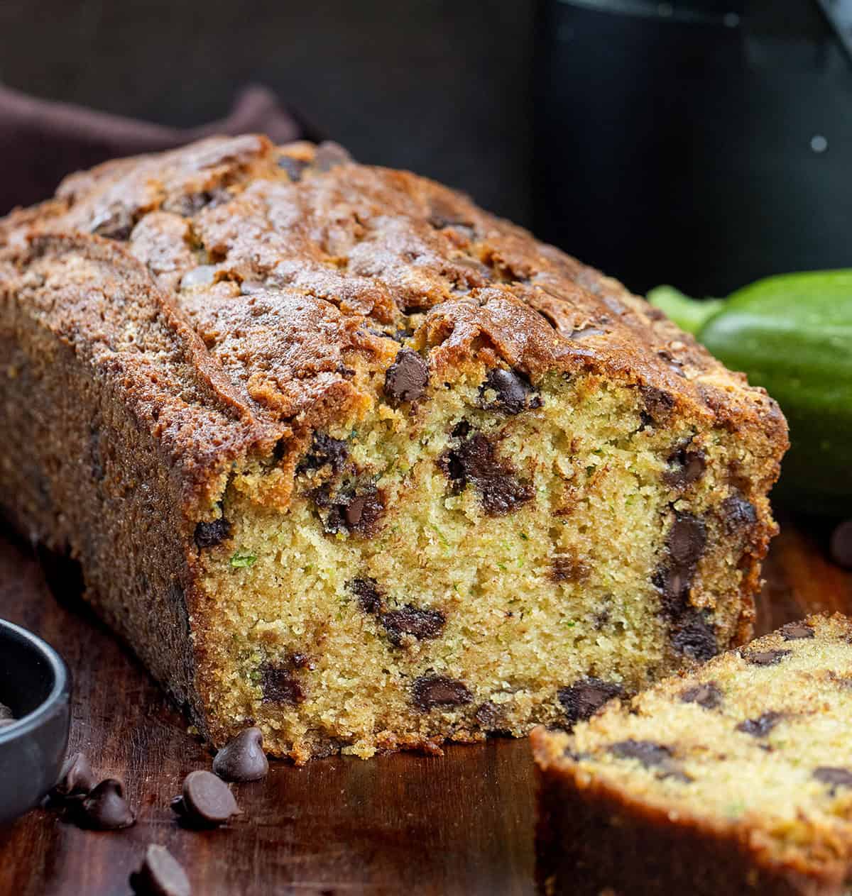 Cut into loaf of Chocolate Chip Zucchini Bread on a wooden table.