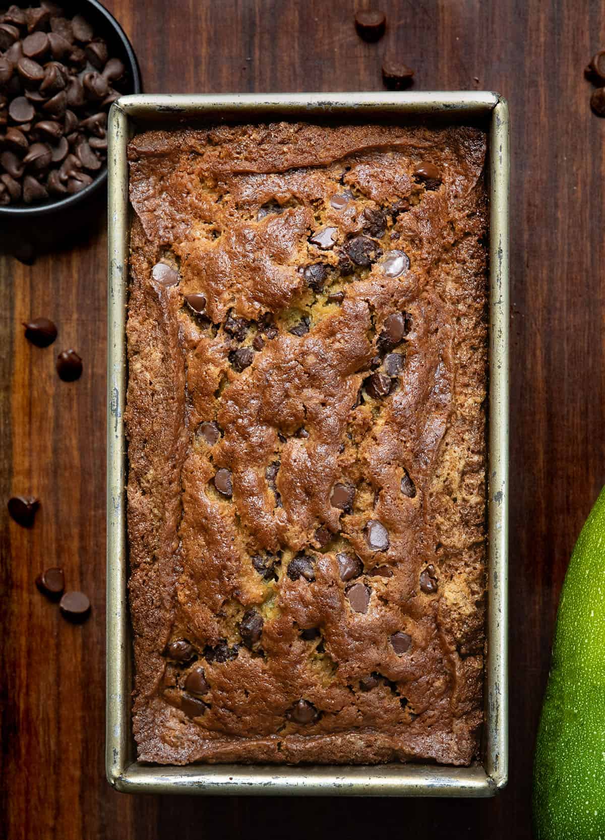 Loaf of Chocolate Chip Zucchini Bread on a wooden table from overhead.