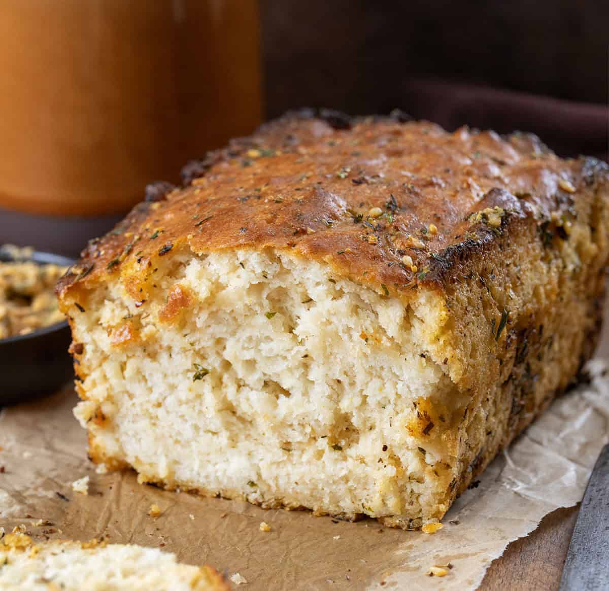 Cut into loaf of Cowboy Butter Swim Bread on a wooden table.
