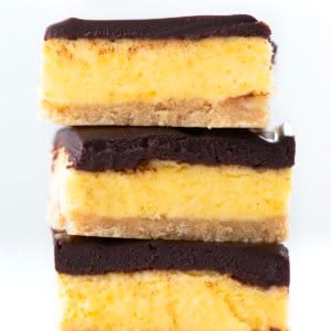 Stack of No Bake Boston Cream Pie Bars on a white table.