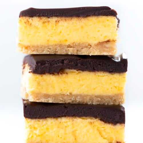 Stack of No Bake Boston Cream Pie Bars on a white table.