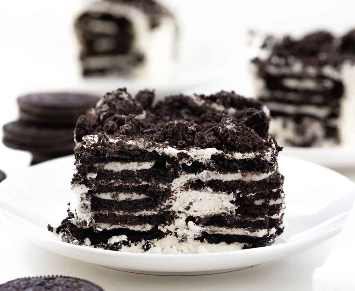 Oreo Icebox Cake slices on white plates on a white table.