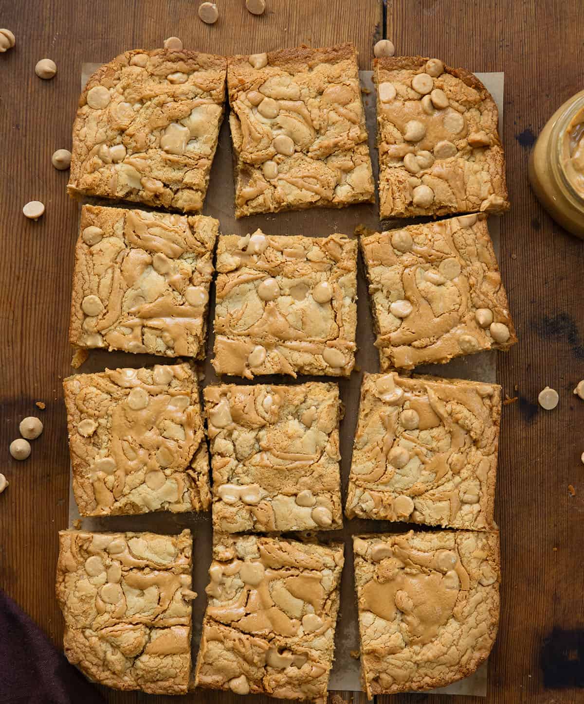 Peanut Butter Overload Blondies cut into squares on a wooden table from overhead.