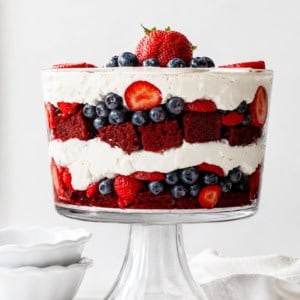 Looking at a Red Velvet Berry Trifle on a white counter top with white dishes and towel.