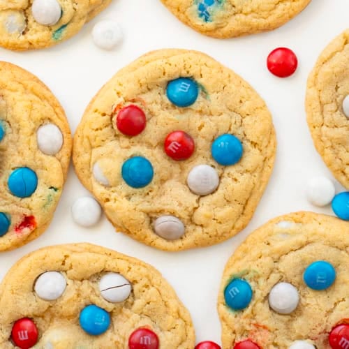 Close up of Red, White, and Blue M&M Cookies on a white table from overhead.