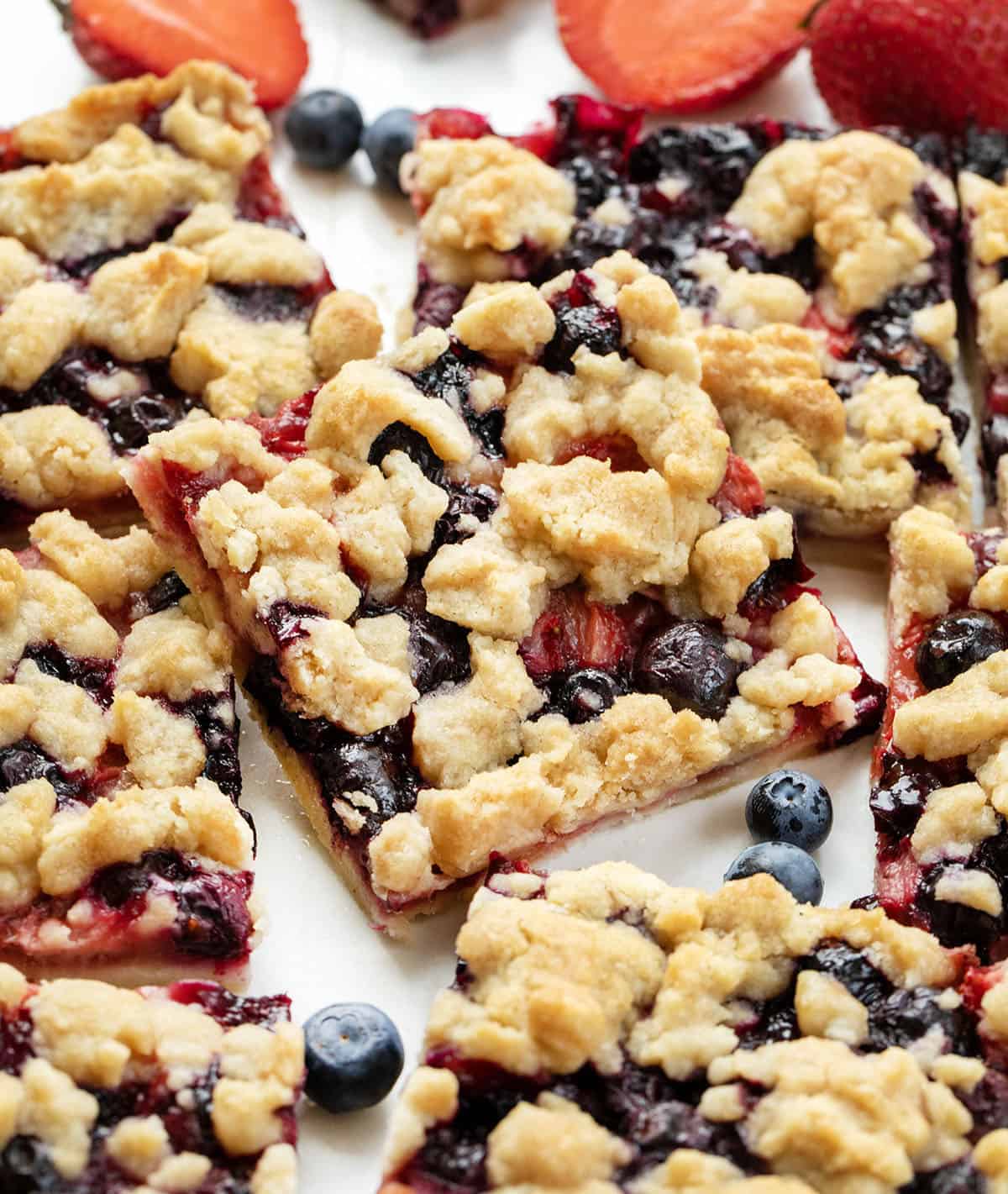 Strawberry Blueberry Crumble Bars cut into squares and on a white table.