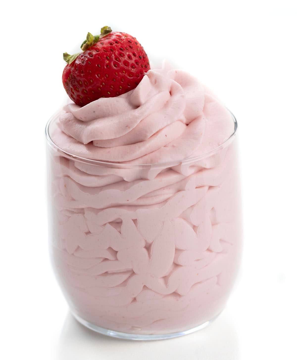Glass of piped Strawberry Stabilized Whipped Cream with a strawberry on top.