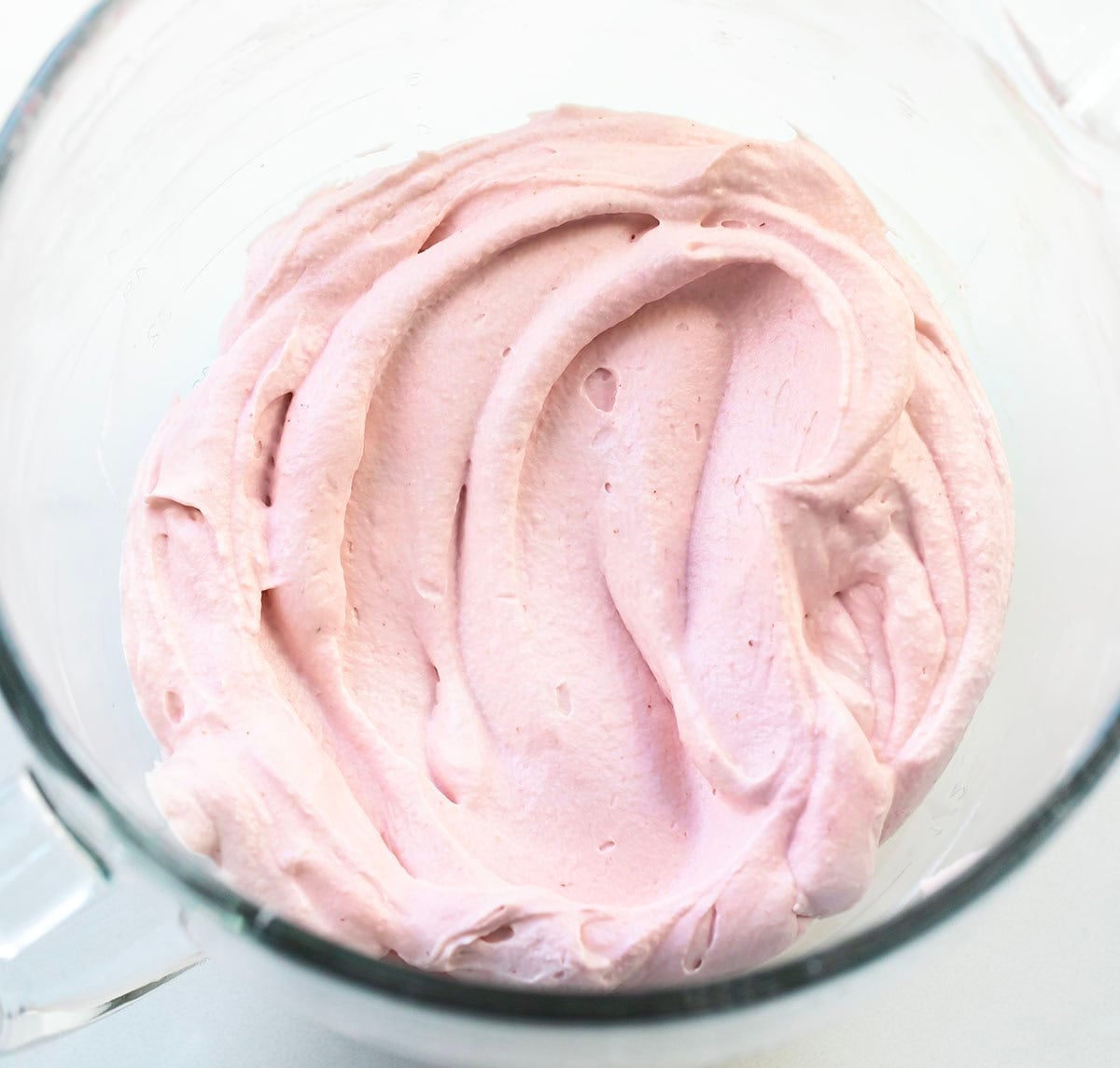 Strawberry Stabilized Whipped Cream in a glass mixing bowl.
