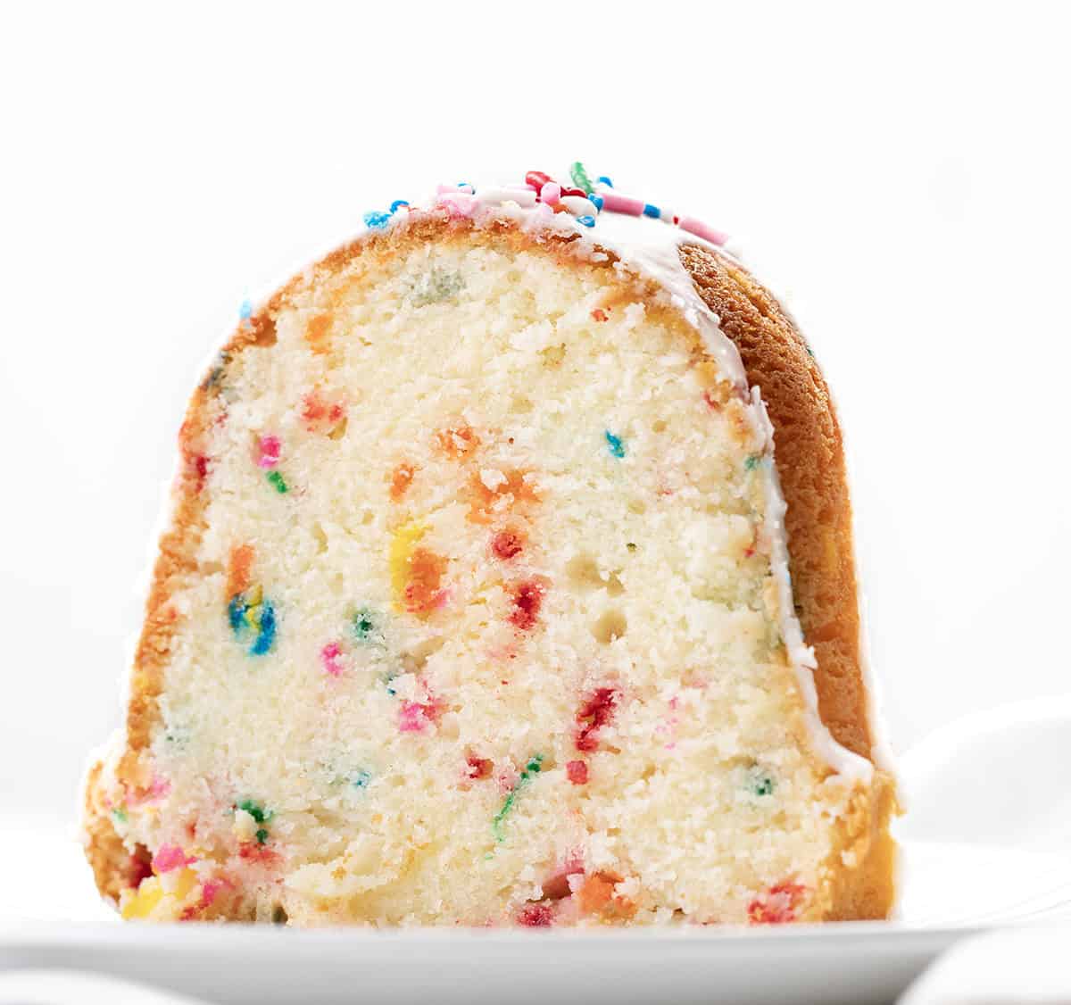 Slice of Birthday Pound Cake on a white plate close up Slice of Birthday Pound Cake on a white plate close up.
