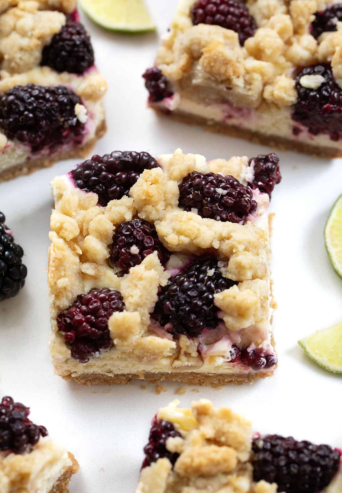 Close up of Blackberry Lime Cheesecake Bar on a white table Close up of Blackberry Lime Cheesecake Bar.