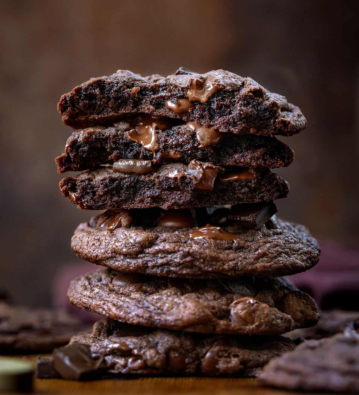 Stack of Bloomed Cocoa Chocolate Chip Cookies with top cookies broken in half showing inside texture.