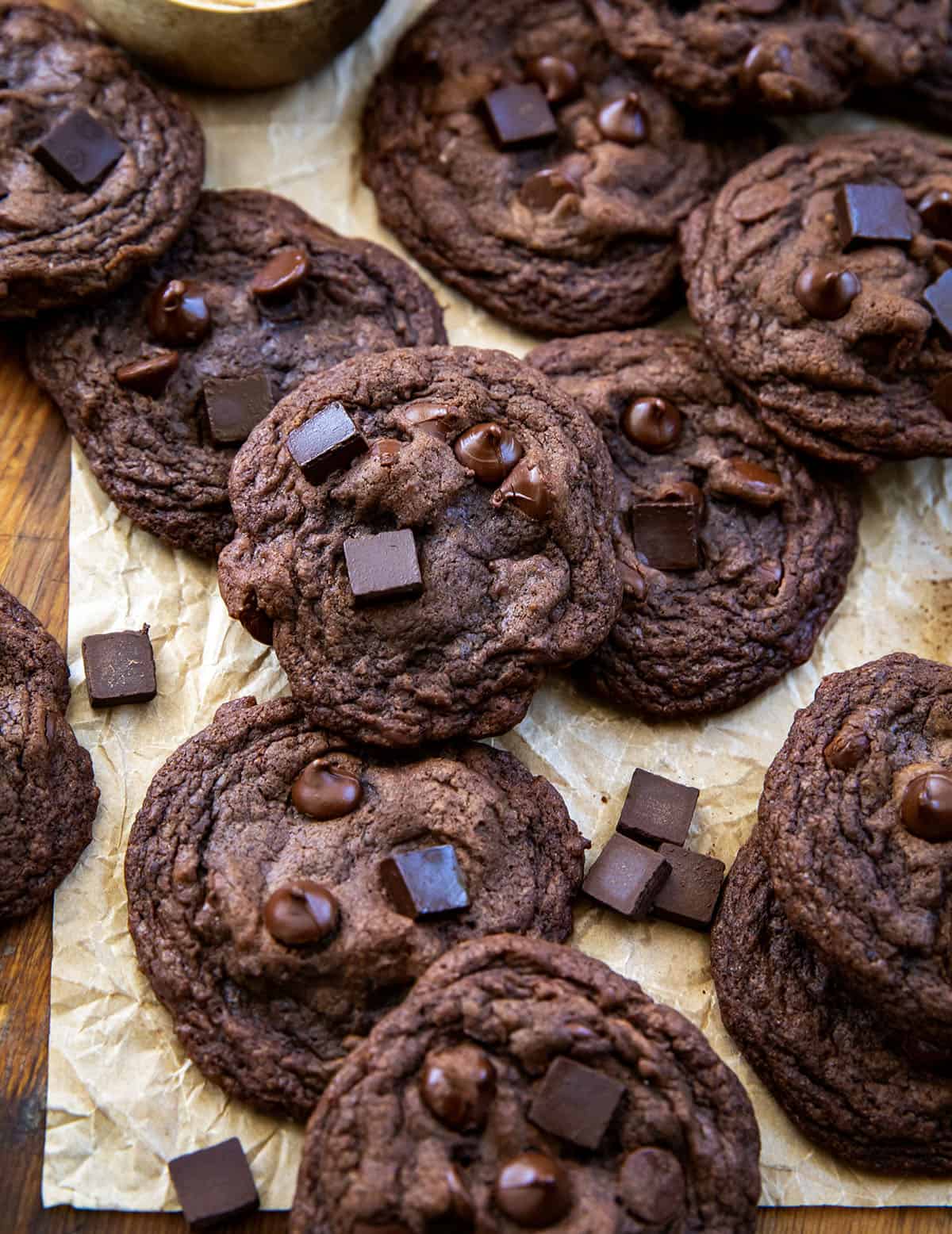 Bloomed Cocoa Chocolate Chip Cookies on a wooden table with cocoa and chocolate chunks from overhead Bloomed Cocoa Chocolate Chip Cookies on a wooden table with cocoa and chocolate chunks from overhead.