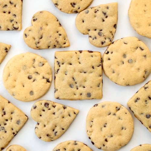 Chocolate Chip Cut-Out Cookies in various sizes on a white table from overhead.