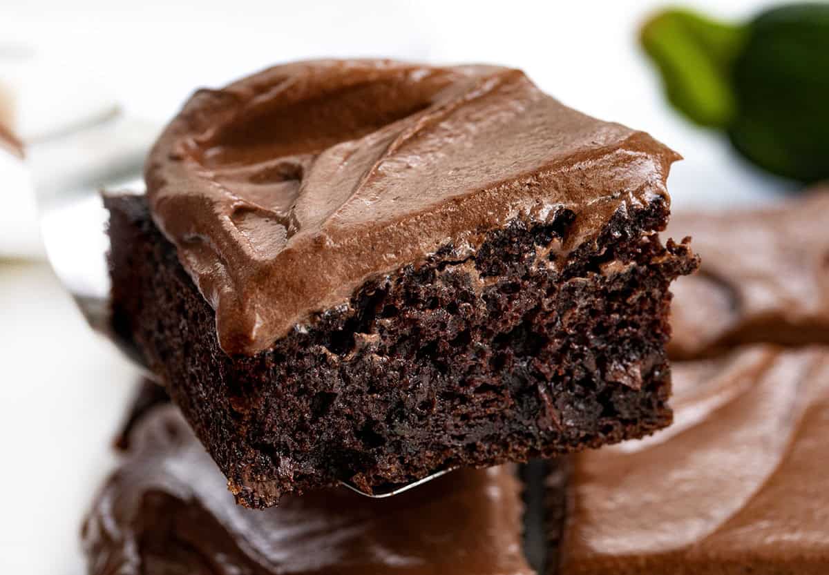 Spatula holding up a pice of Chocolate Zucchini Snack Cake above the pan Spatula holding up a pice of Chocolate Zucchini Snack Cake above the pan.
