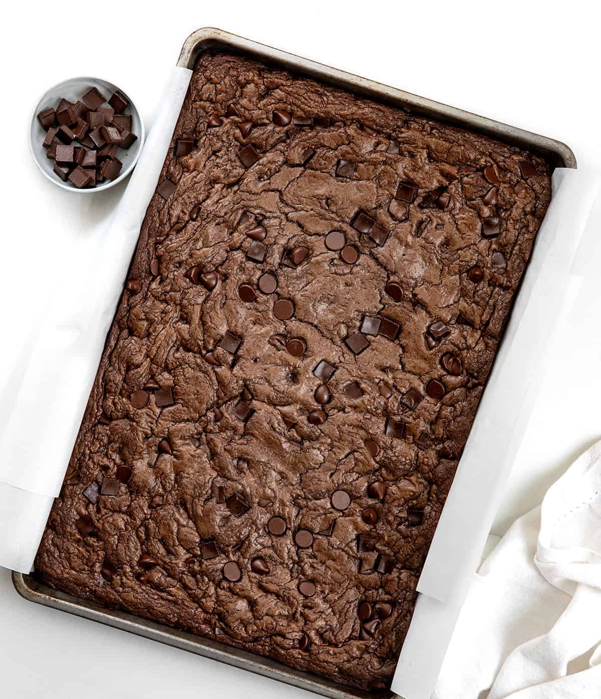 Pan of Double Chocolate Sheet Pan Cookies on a white table from overhead Pan of Double Chocolate Sheet Pan Cookies on a white table from overhead.