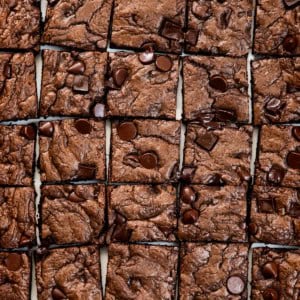 Double Chocolate Sheet Pan Cookies cut into squares on a white table from overhead.