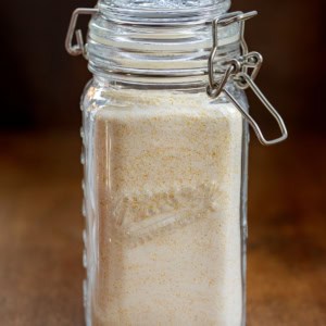 Glass jar of Homemade Cornbread Mix on a wooden table.