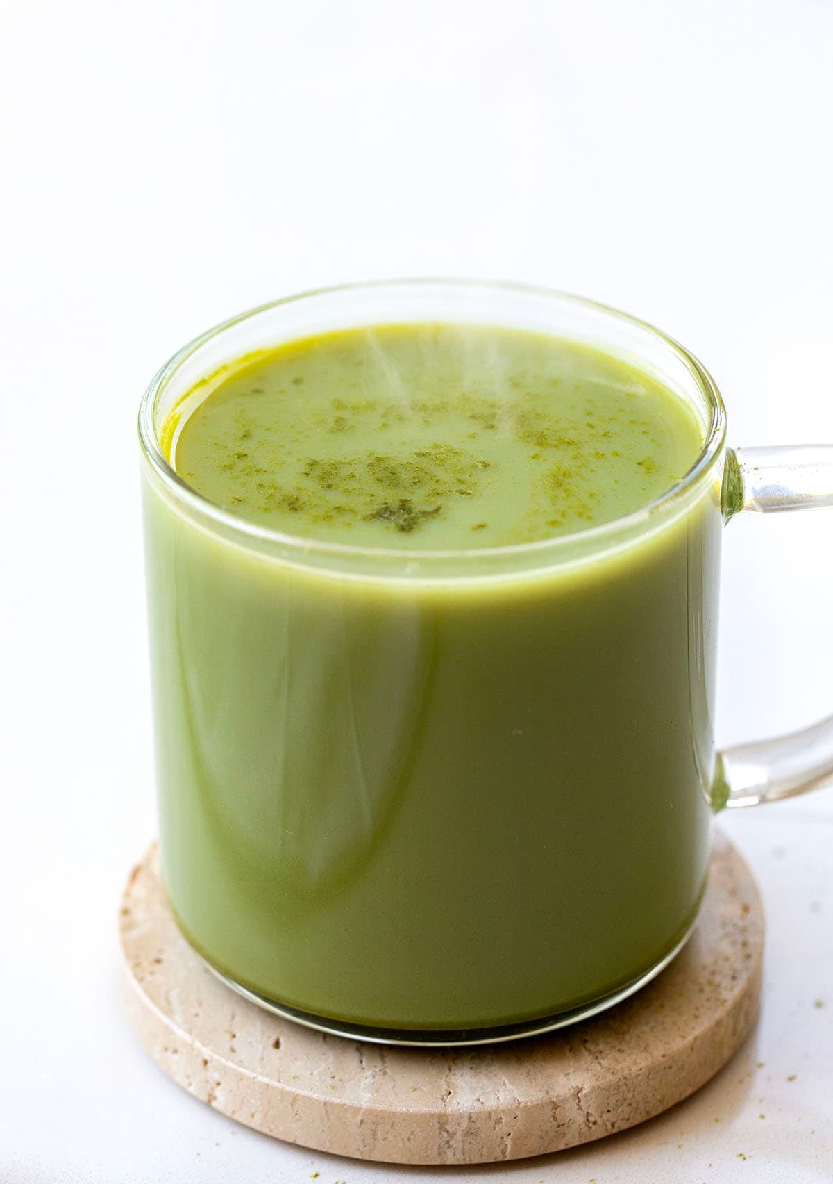 Hot Mug of Matcha Latte Mix on a white table Hot Mug of Matcha Latte Mix on a white table.