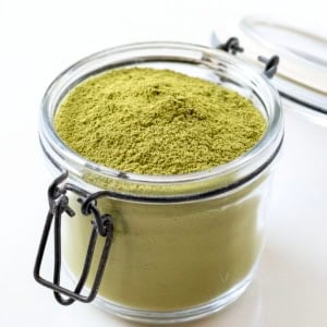 Jar of Matcha Latte Mix on a white table.