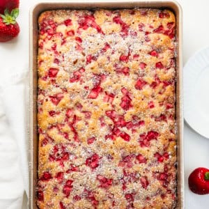 Old Fashioned Strawberry Sheet Cake in a pan on a white table from overhead.