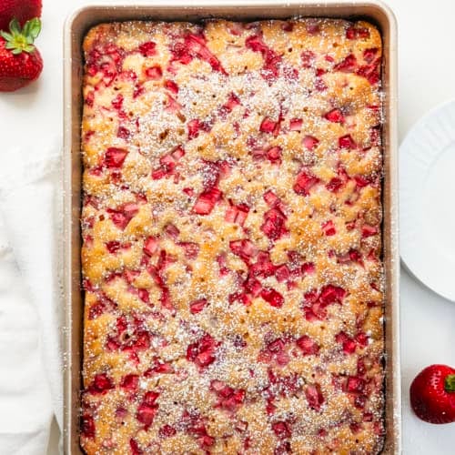 Old Fashioned Strawberry Sheet Cake in a pan on a white table from overhead.