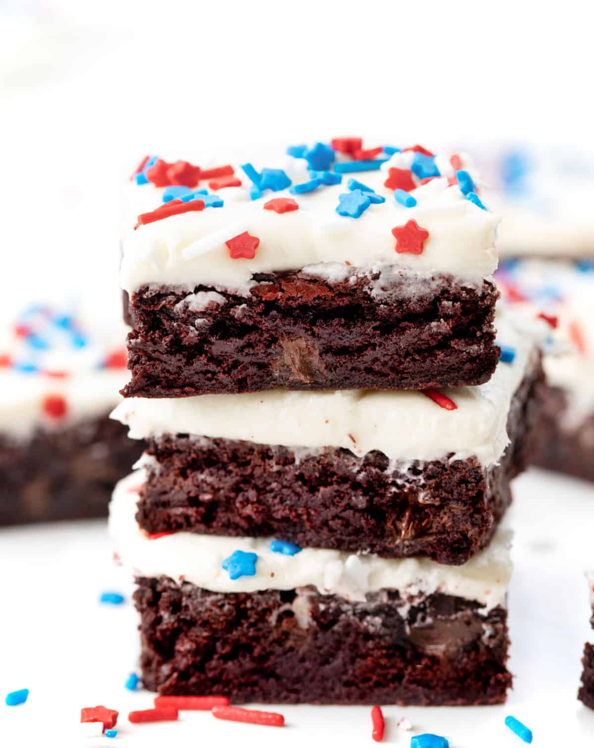 Stack of Patriotic Red Velvet Sheet Pan Brownies on a white table close up.
