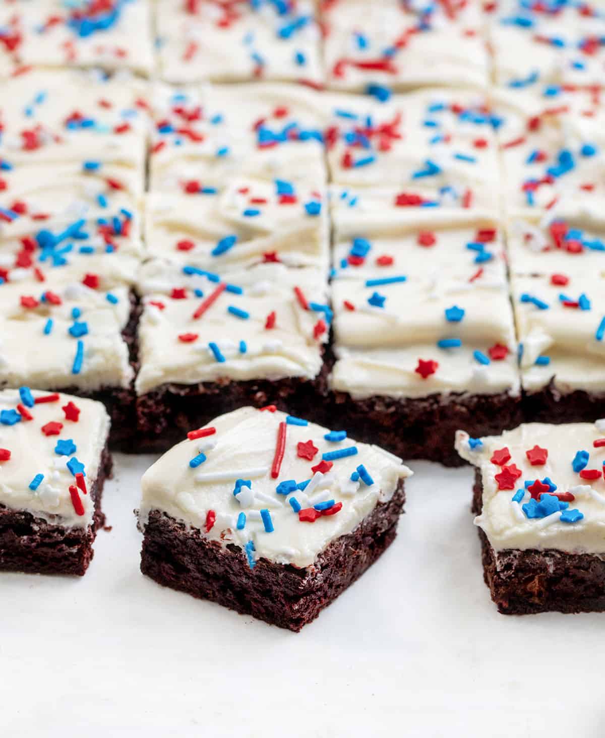 Patriotic Red Velvet Sheet Pan Brownies cut into squares with a few pulled away from the others.