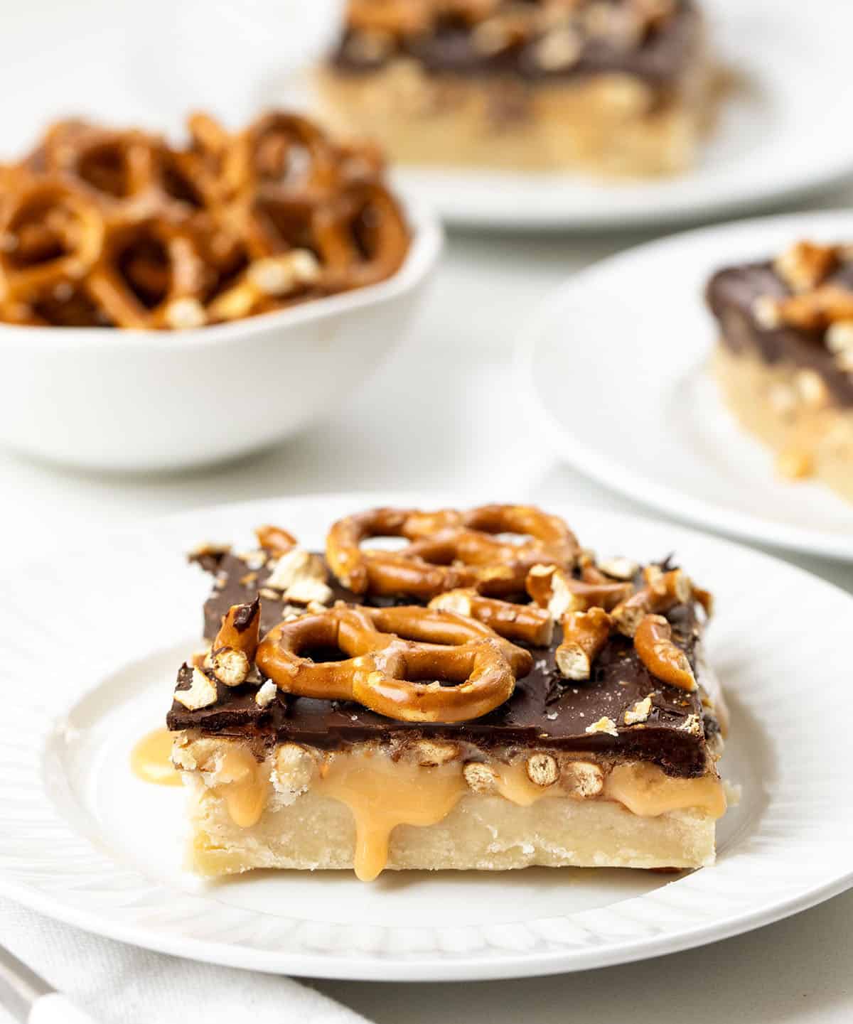 Salted Caramel Pretzel Bars cut into squares on a white table.