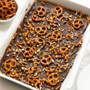 Salted Caramel Pretzel Bars in a white pan on a white table.