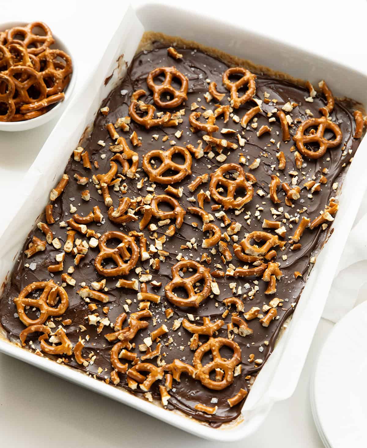 Salted Caramel Pretzel Bars in a white pan on a white table.
