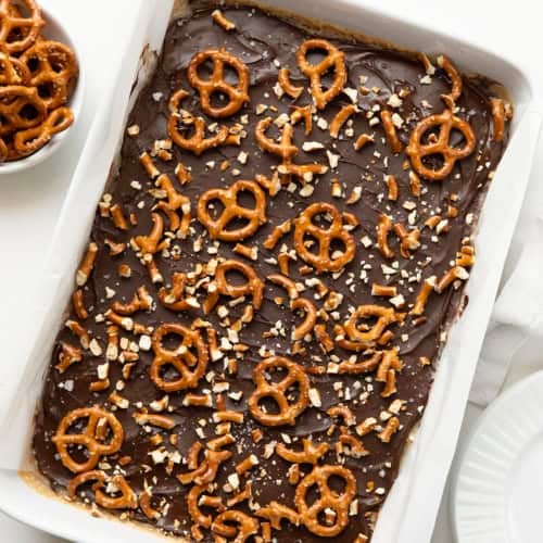 Salted Caramel Pretzel Bars in a white pan on a white table from overhead.
