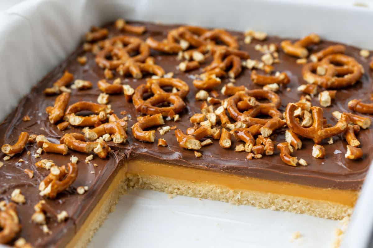 Salted Caramel Pretzel Bars in a pan with some cut out.